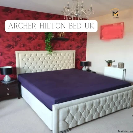 Luxurious bedroom with tufted bed, red floral accent wall, and elegant decor.