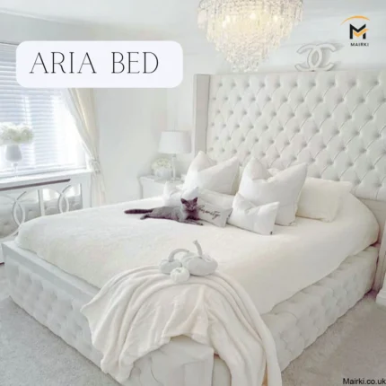 Bedroom with a tufted white bed, red floral accent wall, and crystal chandelier.