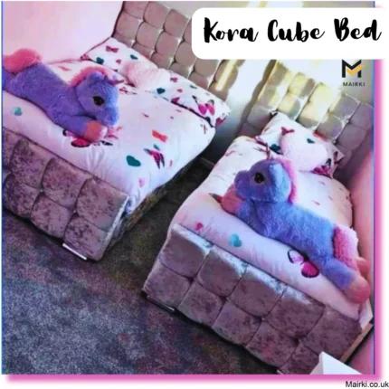 Two children's beds with kora cube-patterned upholstery, colorful heart-patterned duvets, and large purple unicorn plush toys.