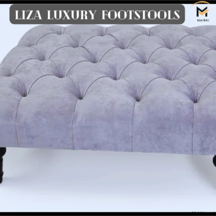 A tufted light gray luxury footstool with black wooden legs and a banner reading "LIZA LUXURY FOOTSTOOLS."