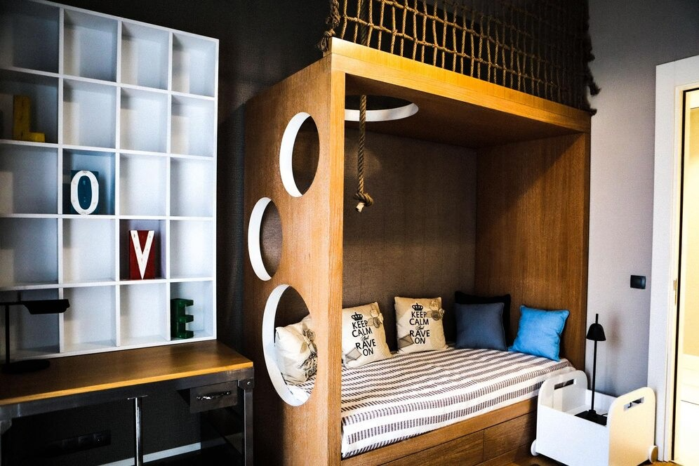 Modern room with a wooden High Sleeper Beds for Adults featuring circular cutouts and a rope design.