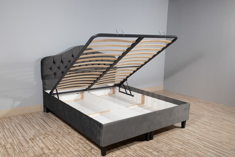 Black ottoman bed with storage space beneath the lifted mattress frame.