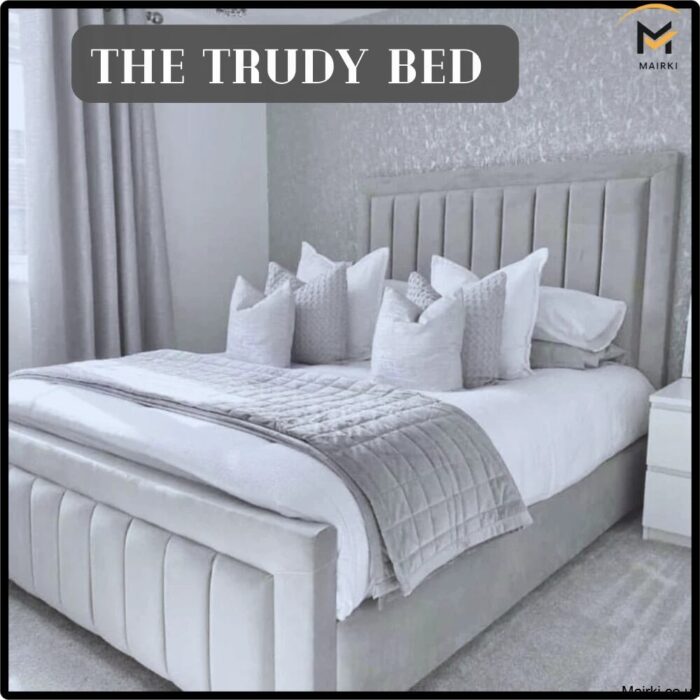 Grey velvet bed with a tall tufted headboard and white bedding in a modern bedroom.