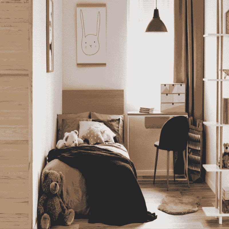 A bedroom with a single wooden bed frame, stuffed toys, a desk under a window, and a rabbit drawing on the wall.